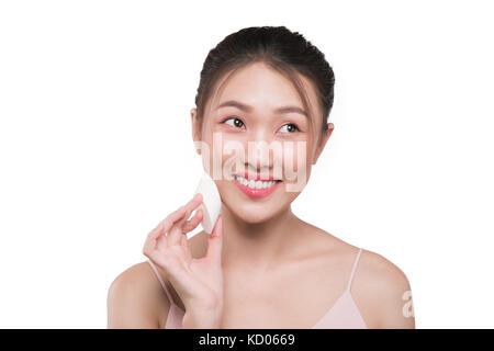Donna attraente mettendo sul make up, liquido applicato foundation sul suo viso Foto Stock