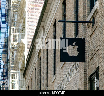 Apple logo aziendale è sospesa al di sopra della porta d'ingresso al loro negozio di SoHo. Foto Stock