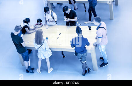 La gente sta cercando i dispositivi fuori messo in mostra in un Apple store. Foto Stock