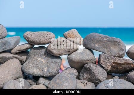 Spiaggia di ciottoli formando una parete con la spiaggia in background, Playa piedras caidas, Fuerteventura, Isole Canarie, Spagna Foto Stock