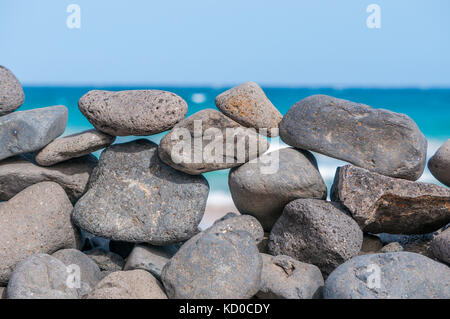 Spiaggia di ciottoli formando una parete con la spiaggia in background, Playa piedras caidas, Fuerteventura, Isole Canarie, Spagna Foto Stock