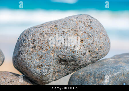 Spiaggia di ciottoli formando una parete con la spiaggia in background, Playa piedras caidas, Fuerteventura, Isole Canarie, Spagna Foto Stock