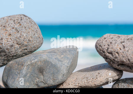 Spiaggia di ciottoli formando una parete con la spiaggia in background, Playa piedras caidas, Fuerteventura, Isole Canarie, Spagna Foto Stock