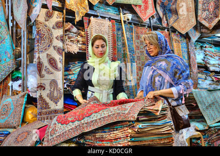 Far provincia, Shiraz, Iran - 19 aprile, 2017: due di moda le donne iraniane, giovane e maturo, vestito in luminose colorate hijabs, scegliere le merci in Foto Stock