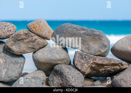 Spiaggia di ciottoli formando una parete con la spiaggia in background, Playa piedras caidas, Fuerteventura, Isole Canarie, Spagna Foto Stock