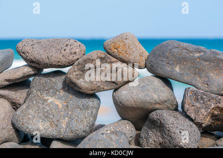 Spiaggia di ciottoli formando una parete con la spiaggia in background, Playa piedras caidas, Fuerteventura, Isole Canarie, Spagna Foto Stock