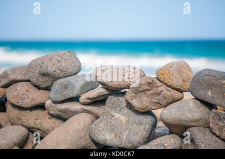 Spiaggia di ciottoli formando una parete con la spiaggia in background, Playa piedras caidas, Fuerteventura, Isole Canarie, Spagna Foto Stock