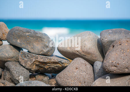 Spiaggia di ciottoli formando una parete con la spiaggia in background, Playa piedras caidas, Fuerteventura, Isole Canarie, Spagna Foto Stock