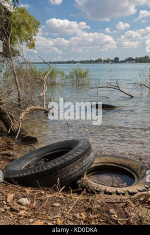 Windsor, ontario canada - pneumatici vecchi lavato fino o oggetto di pratiche di dumping su peche Island, isola city park nel fiume Detroit. Foto Stock