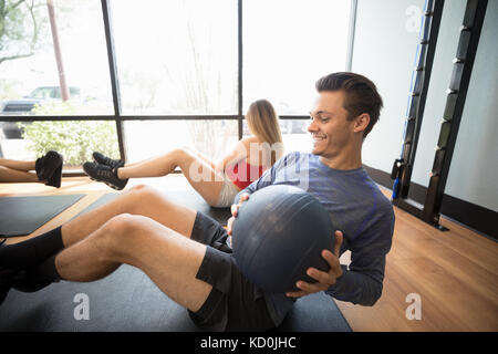 Gli amici di formazione con palla medica in palestra Foto Stock