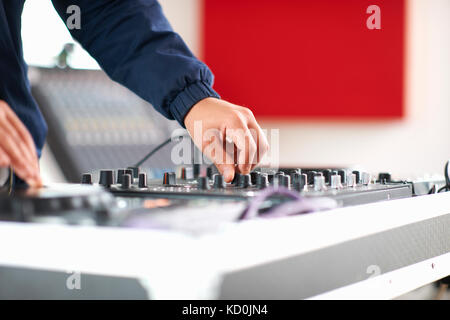 Le mani del collegio maschile dj studente di musica di regolazione sulla console di mixaggio Foto Stock