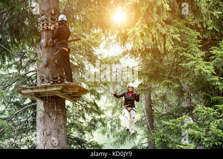 Gli amici nella foresta utilizzando alta fune corso Foto Stock