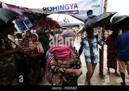 Teknaff, Bangladesh. 8 Ott, 2017. popolazione rohingya e attende per aiuti alimentari durante la pioggia a palongngkhali campo di fortuna in teknaff, Bangladesh in ottobre 08, 2017.Il Bangladesh ha detto che sarebbe stato uno dei più grandi del mondo di camma di rifugiati per alloggiare tutti i 800.000 plus rohingya musulmani che hanno cercato asilo dalla violenza in Myanmar. Credito: zakir hossain chowdhury/zuma filo/alamy live news Foto Stock