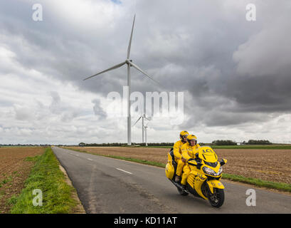 Le gault-saint-denis, Francia - ottobre 08, 2017: il giallo iconico lcl bike guida su una strada in pianura con mulini a vento in un giorno nuvoloso durante la Parigi-tours di ciclismo su strada gara. Credito: radu razvan/alamy live news Foto Stock