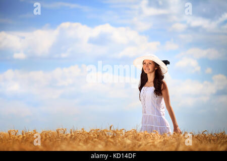 Giovane bella donna in golden campo di grano Foto Stock