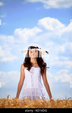 Giovane donna in golden campo di grano godendo nel giorno di estate Foto Stock