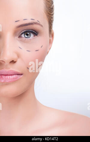 Linee su un attraente dama caucasica faccia come segni per chirurgia plastica estetica Foto Stock