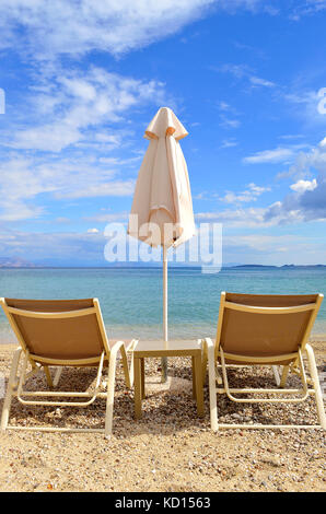 Sedie a sdraio sulla spiaggia di Ipsos a Corfu Foto Stock