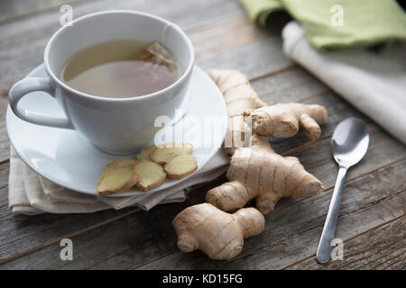 Il tè allo zenzero con radici di zenzero e le fette su tavola Foto Stock