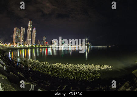 La luce blu del crepuscolo illumina un blocco di alta sorge sopra le strisce le luci di coda rosse di accelerazione sulle vetture di Balboa Avenue di Panama City. La stre Foto Stock