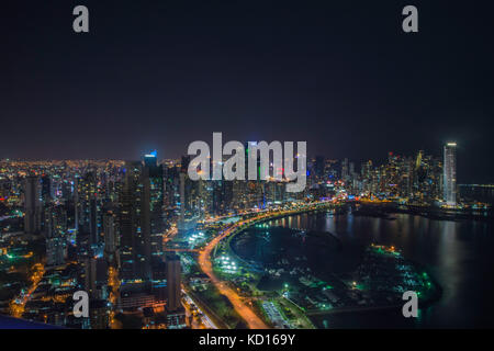 La luce blu del crepuscolo illumina un blocco di alta sorge sopra le strisce le luci di coda rosse di accelerazione sulle vetture di Balboa Avenue di Panama City. La stre Foto Stock