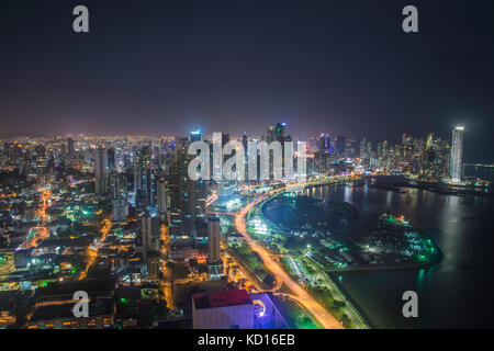 La luce blu del crepuscolo illumina un blocco di alta sorge sopra le strisce le luci di coda rosse di accelerazione sulle vetture di Balboa Avenue di Panama City. La stre Foto Stock