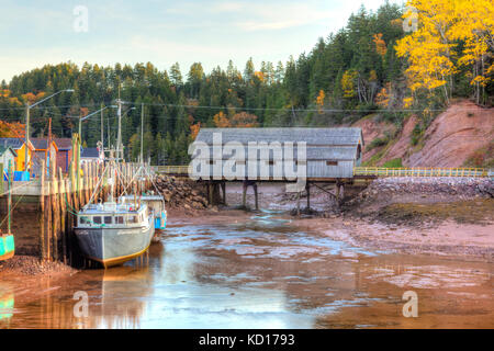 Barche da pesca e ponte coperto con la bassa marea, baia di Fundy, st. martin's, New Brunswick, Canada Foto Stock