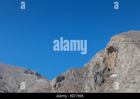 Chiesa isolata in mezzo alla montagna pendenza di Perissa Santorini, Grecia. Foto Stock