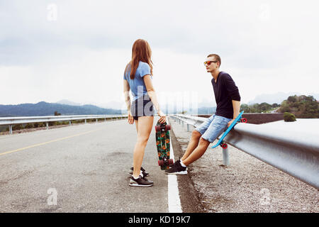 Giovane penny skateboard la marcia su strada Foto Stock