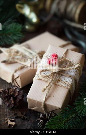 Regali di natale avvolti in marrone carta artigianale con decorazioni di festa Foto Stock