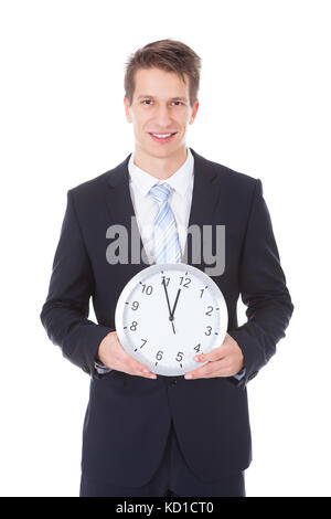Ritratto di giovane imprenditore tenendo l'orologio su sfondo bianco