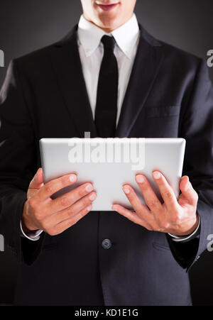 Close-up di un giovane imprenditore utilizzando a tavoletta digitale Foto Stock