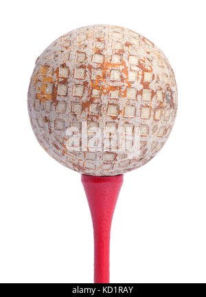 Vecchia pallina da golf su un tee rosso isolato su uno sfondo bianco. Foto Stock