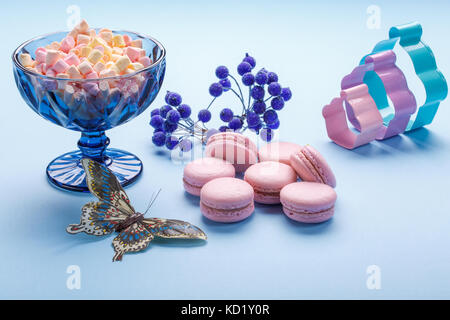 Amaretto di torte con colorati fluffy marshmallows in vaso blu su sfondo blu. Foto Stock