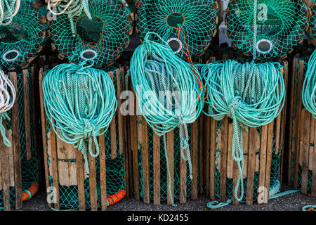 Trappole di astice in piedi su un molo preparato per la pesca con corde e boe Foto Stock