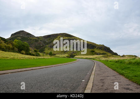 Una strada attraverso il parco hollyrood e Arthur's sede nei pressi di Edimburgo, Scozia Foto Stock