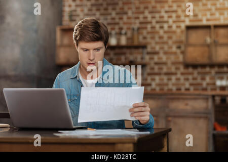 Bel giovane studiando il blueprint Foto Stock