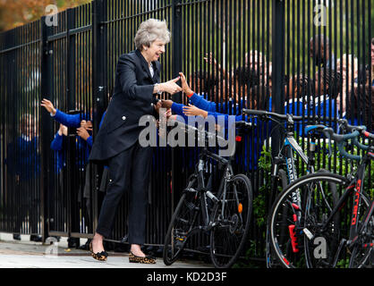 È sotto embargo per 2230 lunedì 9 ottobre il primo ministro Theresa Maggio è accolto da alunni durante una visita alla scuola di dunraven in Streatham, Londra Sud, in vista della pubblicazione dei dettagli del governo di gara disparità audit. Foto Stock