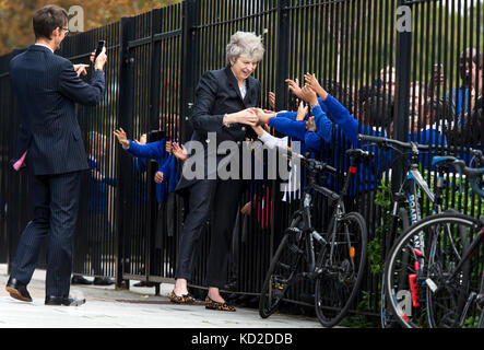 È sotto embargo per 2230 lunedì 9 ottobre il primo ministro Theresa Maggio è accolto da alunni durante una visita alla scuola di dunraven in Streatham, Londra Sud, in vista della pubblicazione dei dettagli del governo di gara disparità audit. Foto Stock