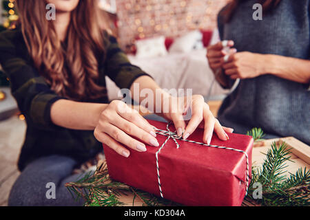 Mano umana legatura di una stringa sul regalo di natale Foto Stock