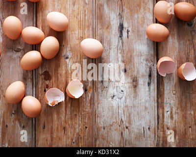 Uova e conchiglie sulla superficie di legno, vista aerea Foto Stock