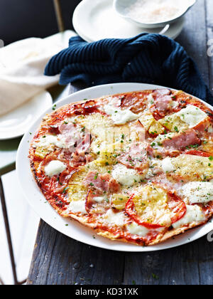 Prosciutto e ananas pizza sulla piastra bianca, close-up Foto Stock