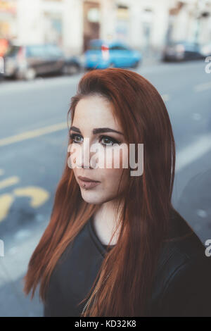 Ritratto di dai capelli rossi donna che guarda lontano Foto Stock
