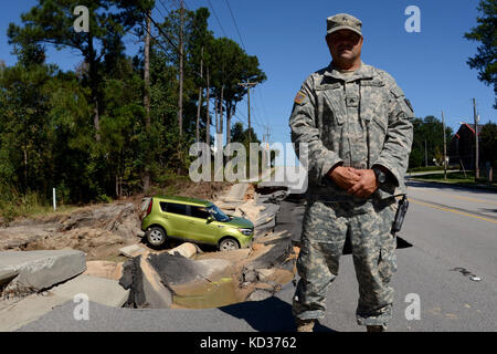 Stati Uniti Army Sgt. Tommy Willingham, una polizia militare di team leader assegnato per la 132Polizia Militare azienda della Carolina del Sud Esercito Nazionale Guardia in West Columbia, protezioni di una strada che è stato lavato fuori nel diluvio durante un statewide Flood response, 11 ott. 2015. La Carolina del Sud la Guardia Nazionale è stata attivata per il supporto di stato e contea di gestione di emergenza e le agenzie locali di prima emergenza come storico impatti di allagamento contee statewide. Ci sono 2,541 Guardia Nazionale attività sul terreno, che include supporto tecnico dalla vicina North Carolina, e più di 40 guardia di stato Foto Stock