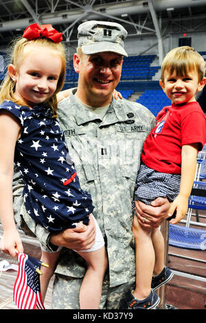 Capt. adam smith riunisce con i suoi figli di Kate e charlie presso la casa accogliente cerimonia per i soldati della sede e sede società, 218th manovra brigata di miglioramento (MEB), al campo mcalister house presso la cittadella giugno 4, 2013. L'unità distribuite per il Kosovo a sostegno della forza per il Kosovo (KFOR) 16 ed eseguito un certo numero di compiti come parte del multi-nazionale task force-est al fine di mantenere un ambiente sicuro e protetto per i residenti del Kosovo durante il loro periodo di nove mesi di tour. (L'esercito degli Stati Uniti Guardia nazionale foto di Sgt. brian calhoun / rilasciato) Foto Stock
