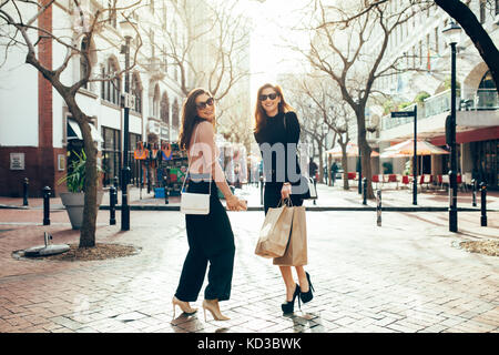 Happy amici shopping. Lunghezza completa di due belle giovani donne godendo di shopping in citta'. Foto Stock