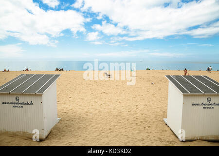 Ampia foto della spiaggia con persone, spiaggia di capanne, gabbiani in una giornata di sole con nuvole. oostende, Belgio. Foto Stock