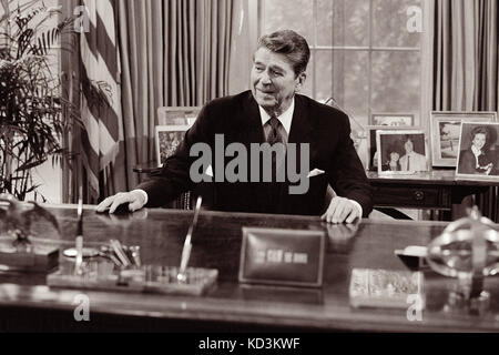 Il presidente Ronald Reagan alla sua scrivania presso l'ufficio ovale della Casa Bianca. Foto Stock