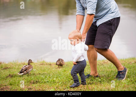 Irriconoscibile il padre e il figlio di trascorrere del tempo insieme al di fuori nel verde della natura. Foto Stock