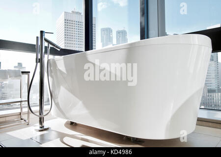 Una vasca da bagno indipendente in un hotel in Giappone con vedute chiare degli edifici di Shinjuku Foto Stock